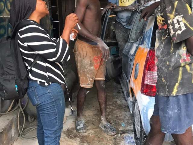 A HERO Network volunteer distributing HIV self-testing kits and educating workers at a mechanic shop